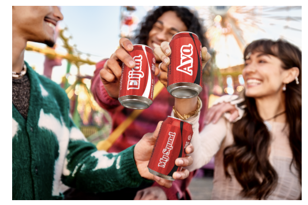 Friends cheering with cans of Coca Cola