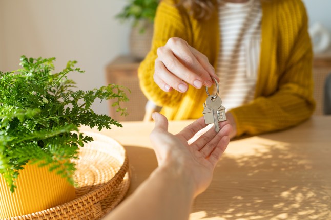 Close-up of hand over of house key in new home.