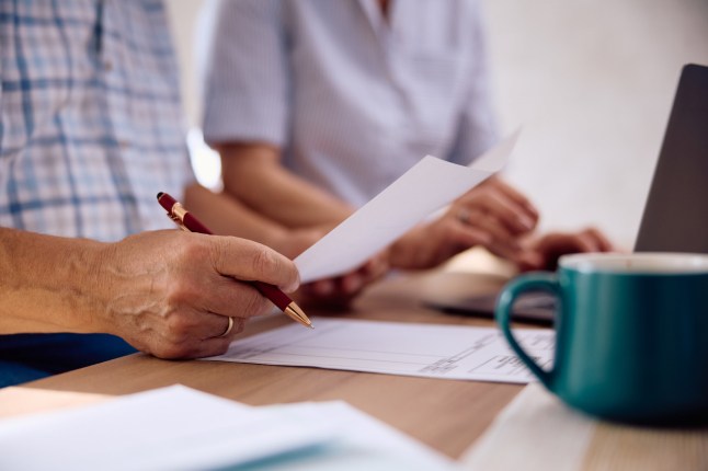 Close up of senior man analyzing paperwork with his wife at home.