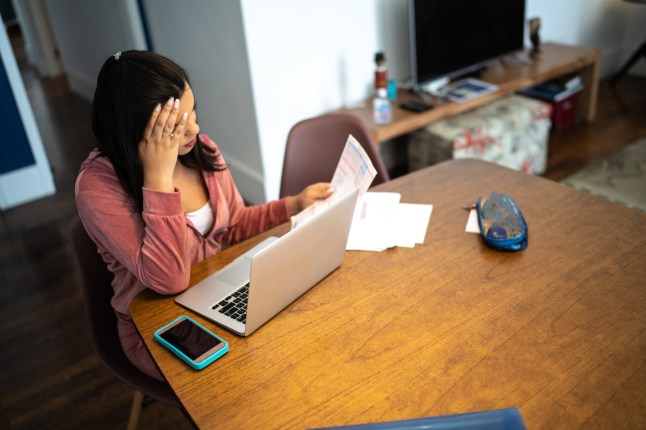 Worried transgender woman looking for financial bills at home